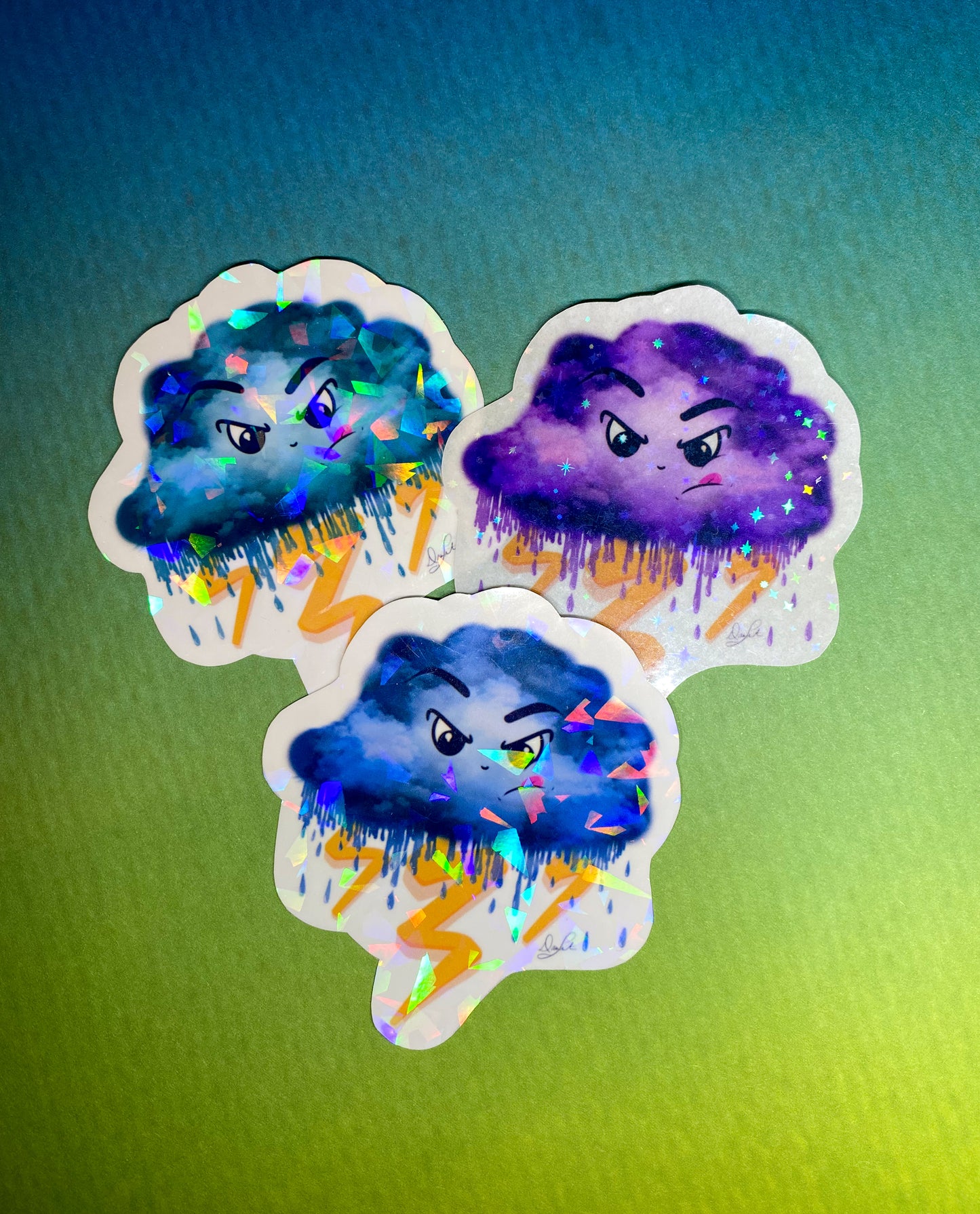 Three cloud stickers, one teal, one purple, one blue. 