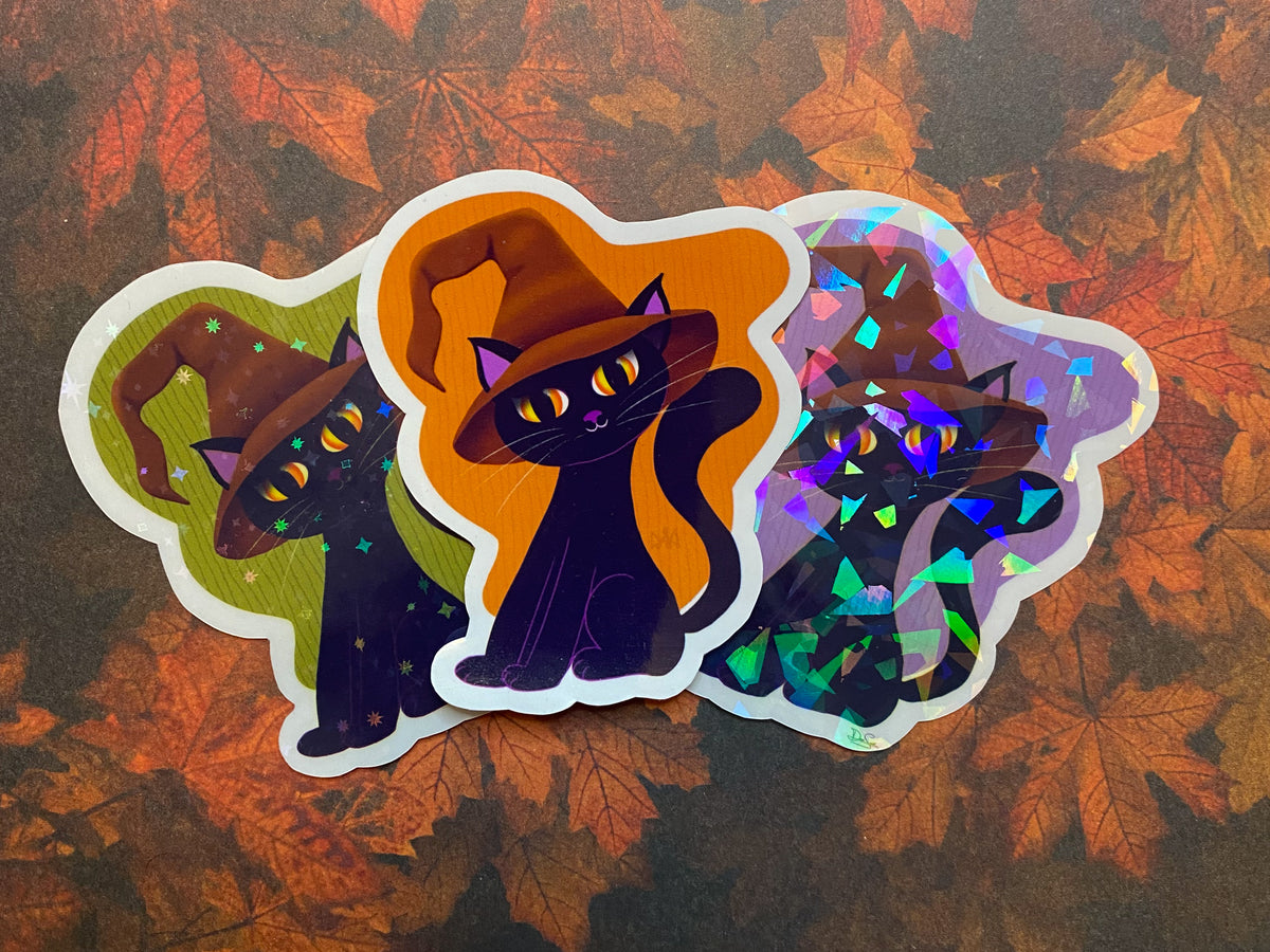 Three black cat stickers with different backgrounds and finishes. Green background with stars, orange background with clear, and purple background with shards.