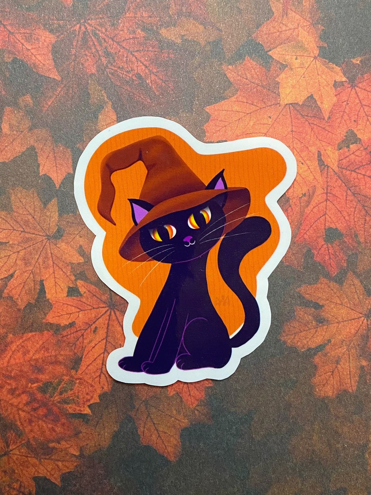 Black cat sticker with an orange background