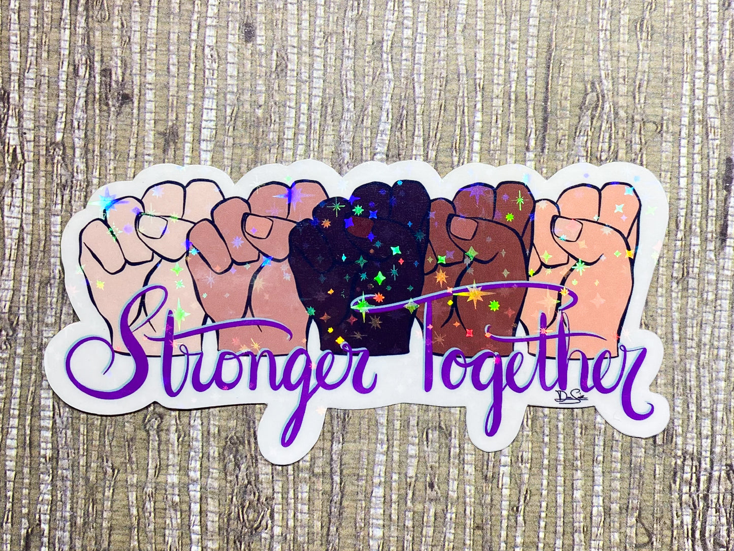 Image shows a sticker featuring five fists in various skin tones above the words Stronger Together in purple, cursive font 